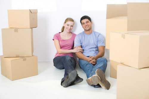 Packed moving boxes and removal team preparing a Newburypark house move